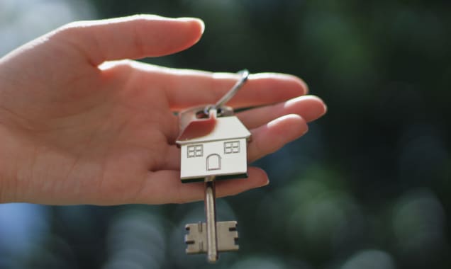 hand holding a key to a new house